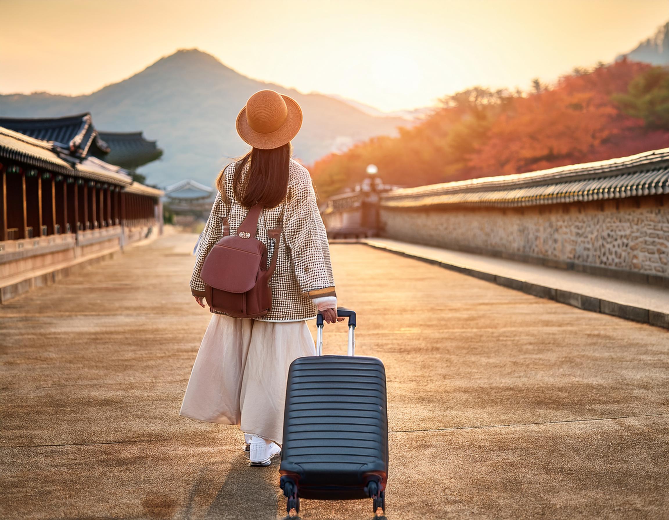 スーツケースを持って旅立つ女性