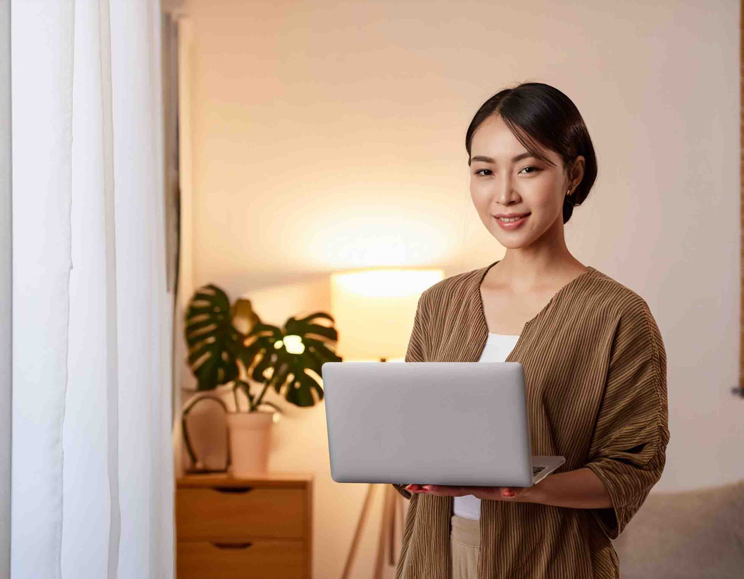 自宅でノートPCを持つ女性