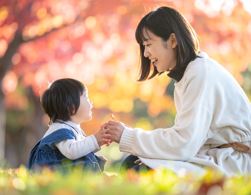 赤ちゃんと公園で遊ぶ母親
